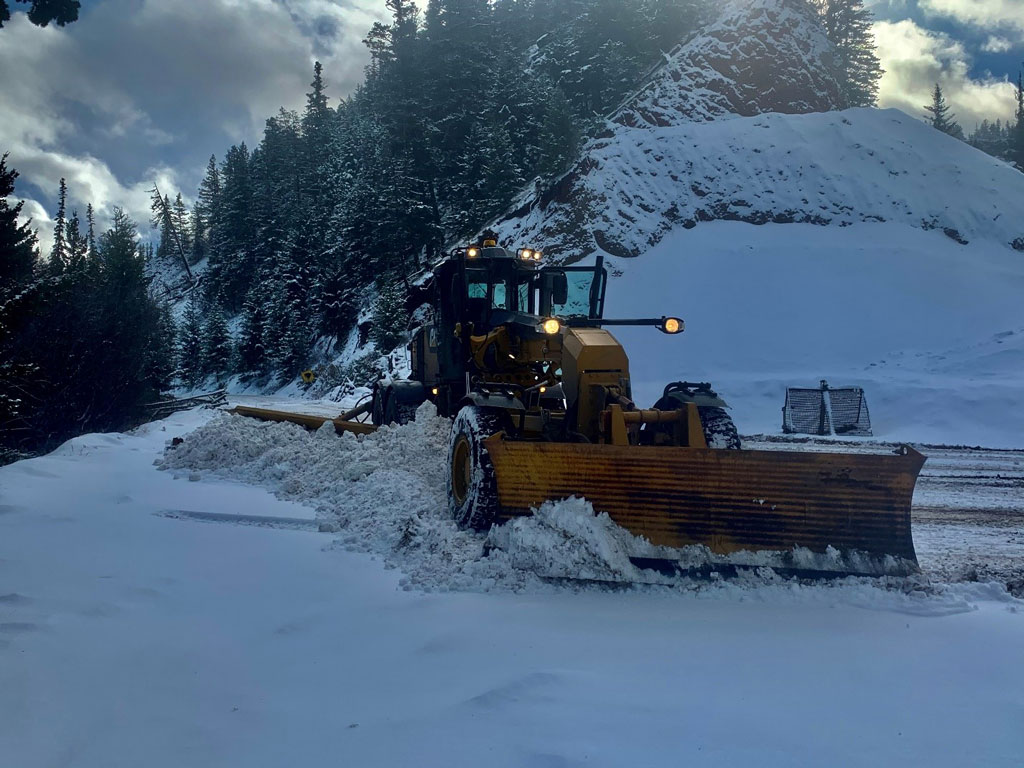 A grader plows snow off the West Pavilion Road.